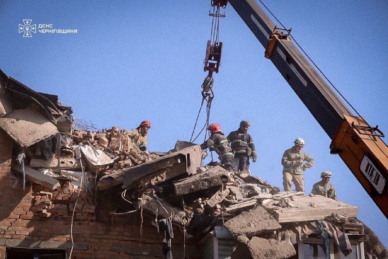 Rescuers on the rubble with the crane