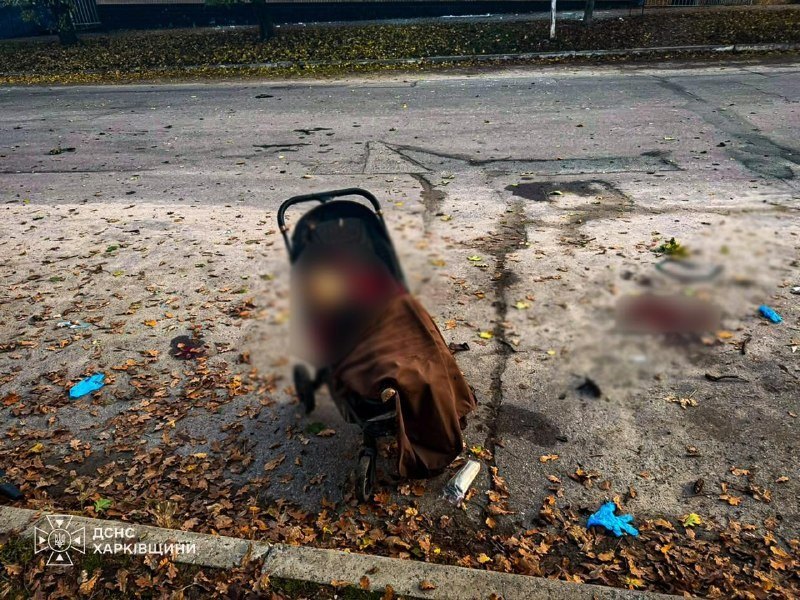 A child's stroller at the impact site — graphic aftermath, blurred