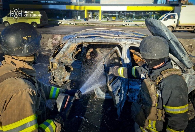 Chabany, región de Kyiv, 20 oct.: rescatistas apagan un coche incendiado por el ataque con dron cerca de la autopista Kyiv–Odesa