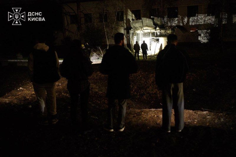 Kyiv, night of 26 Oct: people outside a damaged building with its windows blown out
