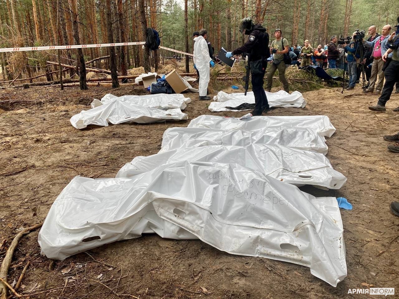 Housses mortuaires sur le site d'exhumation — conséquences choquantes, image floutée
