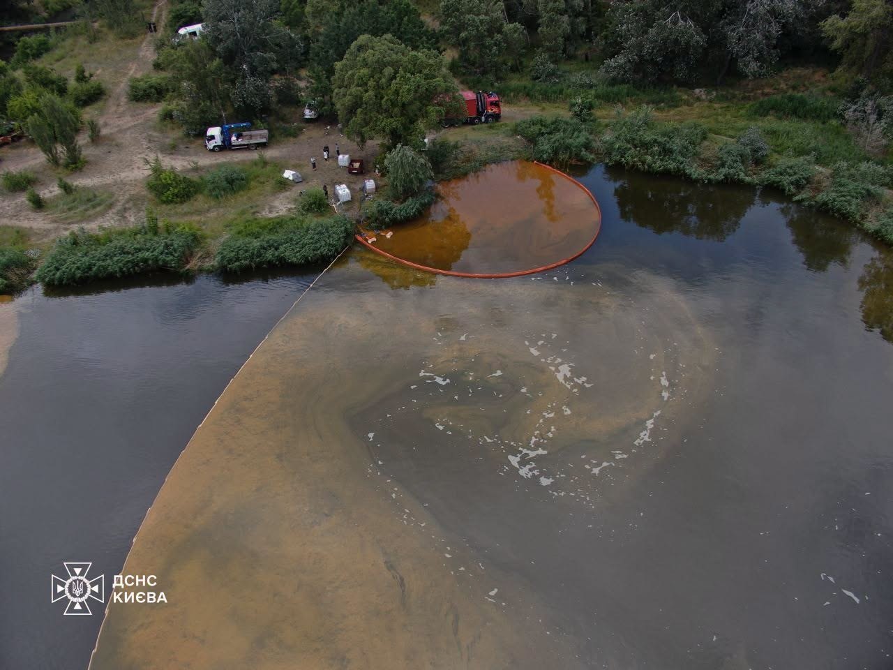 Rescuers clean petroleum products from Kyrylivske Lake after a strike on a nearby site